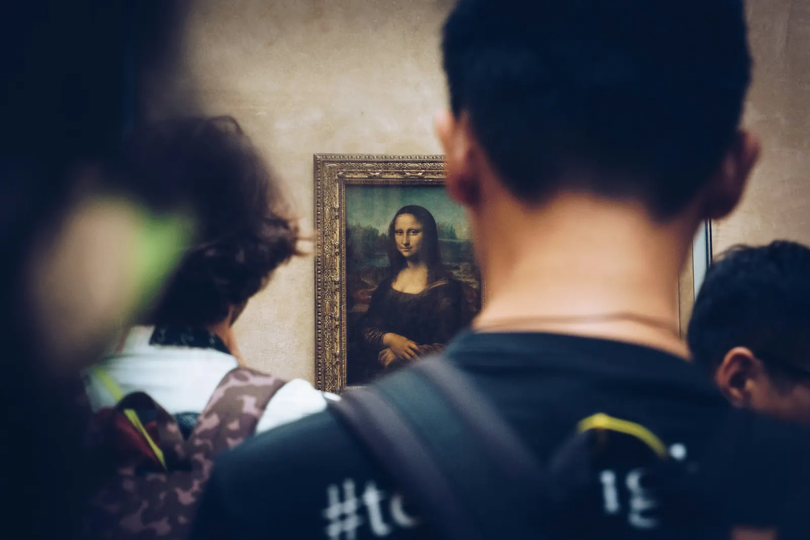 Bezoekers in een museum kijken naar de Mona Lisa in haar lijst.